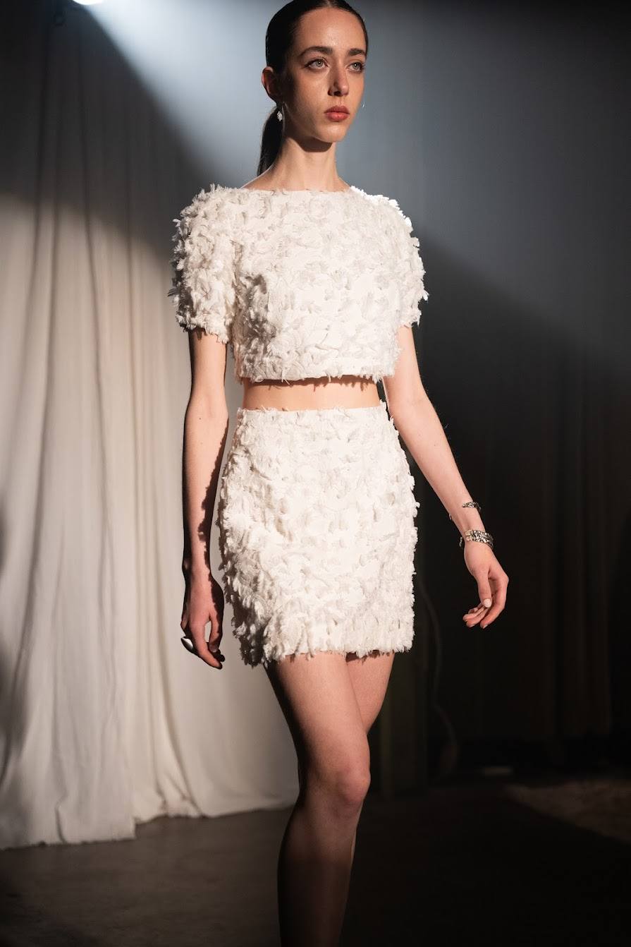 Modelo desfilando con conjunto blanco texturado